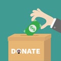 Human hand putting paper money bill with dollar sign into donation paper cardboard box. Helping hands concept. Donate and help pet Royalty Free Stock Photo