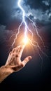 Human hand reaching to touch powerful bright lightning bolt in a dark dramatic stormy sky Royalty Free Stock Photo