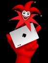 Human hand with a red smiled Joker head on the finger holding ac Royalty Free Stock Photo