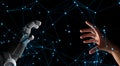 Human hand and robot hand with network connection lines on black screen background, artificial intelligence, AI, in futuristic Royalty Free Stock Photo