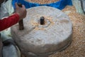 Human hand rotating stone grinding machine for smashing grains. Handmade manual equipment grind mill