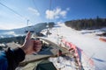 Human hand with thumb-up gesture on background of mountain ski-lift rope way on sunny winter day. Royalty Free Stock Photo