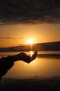 human hand trying to hold the sun, Laranjal beach in southern Brazil