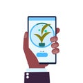 Human hand using mobile app smart control farming system agriculture concept smartphone screen modern organic plants