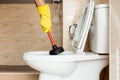 Using a device to fix a clogged toilet bowl Royalty Free Stock Photo