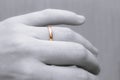 Human hand with a wedding ring on a finger close-up. Black and white hand and gold ring. Royalty Free Stock Photo