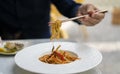 Human hand which raises the udon to the vegetables with chopsticks