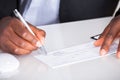 Human hand writing on cheque Royalty Free Stock Photo