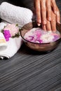 Human hands in bowl with oil and flower Royalty Free Stock Photo