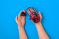 Human hands with car key and toy car model tied with a red ribbon and bow as present. Car for sale concept