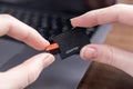 Human hands carefully connect a small microSD memory card into a black ADAPTER, enabling seamless digital data transfer and Royalty Free Stock Photo