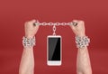 Human hands chained to the phone.