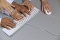 Human hands on computer keyboard with one hand using computer mouse Royalty Free Stock Photo