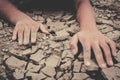 Human hands on cracked dry ground Royalty Free Stock Photo