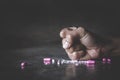 Human hands crushing pink pills on dark background. Stop drug addiction concept.  International Day against Drug Abuse. Copy Space Royalty Free Stock Photo