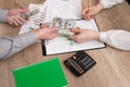 Human hands exchanging money above business graph