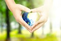Human hands holding the earth with heart shape in the park Royalty Free Stock Photo