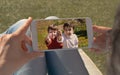 Human hands holding mobile looking at a picture of two twin children