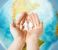 Human hands holding paper family over earth globe Royalty Free Stock Photo