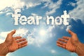Human hands pointing at the writing fear not from clouds in the sky Royalty Free Stock Photo