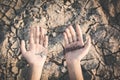 Human hands praying for the rain on cracked dry ground Royalty Free Stock Photo