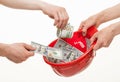 Human hands putting dollars in a red hard hat Royalty Free Stock Photo