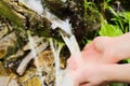 Human hands taking pure, fresh, drinking water from natural source.