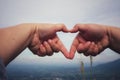 Human hands together in heart shape selectable focus sky background love day concept.