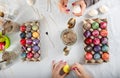 human hands of two sorbian women are painting with melting wax with a trimmed goose quill and a needle head on the surface of the