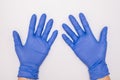 Human hands wearing blue surgical latex nitrile gloves for doctor and nurse protection during patient examination on white