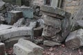 A human head carved in stone with many other rocks strewn around.