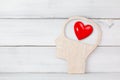 Human Head and Red Heart inside brain shape over white wood background. Symbol for falling or being in love, liking, emotions and