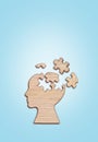 Human head silhouette with a jigsaw piece cut out on the blue background, mental health concept. Royalty Free Stock Photo