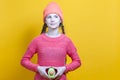 Human Health Concepts. Teenager Girl In Coral Knitted Clothing With Split Avocado Fruit In Front of Belly as a Demonstration of