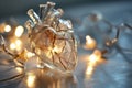 Human heart made of glass or ice with light garland. Anatomically correct heart on bokeh background. Glowing frozen heart, love