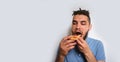 Human holds piece of cheese pizza with tomatoes in his hands and enjoys eating. Young cute Caucasian man with beard and dreadlocks Royalty Free Stock Photo