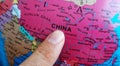 Finger pointing to the country of China on a Globe