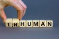 Human or inhuman symbol. Businessman turns wooden cubes and changes the word inhuman to human. Beautiful grey table grey Royalty Free Stock Photo