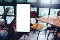 Human left hand using smartphone mobile blank space for your text of white screen display in the cafe coffee shop and wooden table Royalty Free Stock Photo