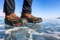Human legs in hiking boot in ice crampons on the texture Baikal Royalty Free Stock Photo