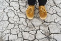 Human legs standing on dried cracked earth Royalty Free Stock Photo