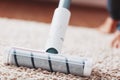 Human legs and a white turbo brush of a cordless vacuum cleaner cleans the carpet in the house Royalty Free Stock Photo