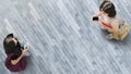 Human life in Social distance. Aerial top view with two student women with smartphone stand at grey pavement street road with