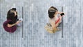 Human life in Social distance. Aerial top view with two student women with smartphone stand at grey pavement street road with