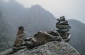 Human-made pile of stones - cairn as way marker in foggy mountain