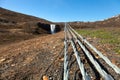 Human and nature: clean water of waterfall and asphalt road on a stony rocky mountain landscape of Iceland Royalty Free Stock Photo