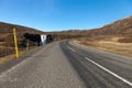 Human and nature: clean water of waterfall and asphalt road on a stony rocky mountain landscape of Iceland Royalty Free Stock Photo