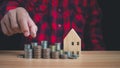 Human puts money on pile of coins. Ideas for investing and growing a business, maximizing profits from business, ideas for setting