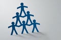 Human pyramid of paper cut-out people on white background - Concept of teamwork Royalty Free Stock Photo
