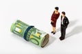 Human representation of a couple looking at a Roll of money Royalty Free Stock Photo